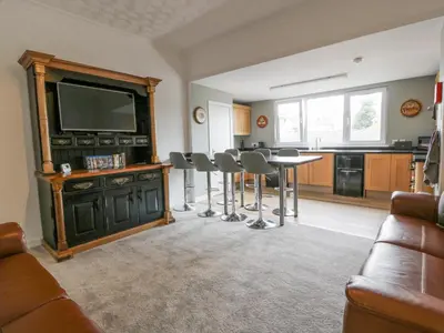 a living room with a television and a table and chairs at Little Ireland in Stranraer
