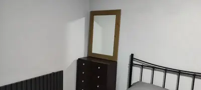 a mirror on top of a dresser next to a bed at A Whole Terrace house to you in Distington