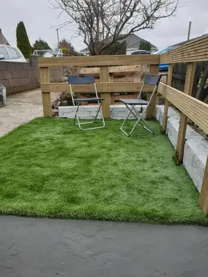 two chairs sitting on grass next to a fence at A Whole Terrace house to you in Distington
