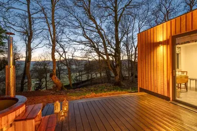a wooden deck with a view of a giraffe at Crocus Penruddock, dog & eco friendly lodge with hot tub in Penruddock