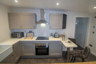 a kitchen with a sink and a stove top oven at Shepherds Retreat Hutton John in a walled garden in a rural setting only 10 minutes for Lake Ullswater in Penruddock