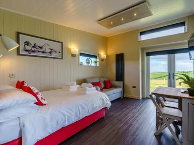 a bedroom with two beds and a desk and a table at 1 Bed in Turnberry 78071 in Girvan