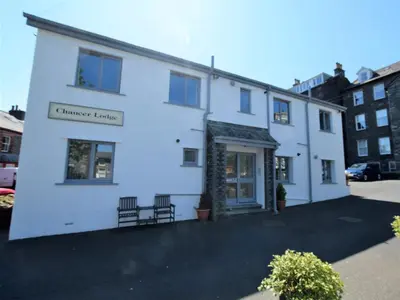 a white building with two chairs in front of it at 1 Bed in Keswick oc-85419 in Keswick
