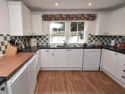 a kitchen with white cabinets and a sink and a window at 2 Bed in Caldbeck SZ212 in Caldbeck