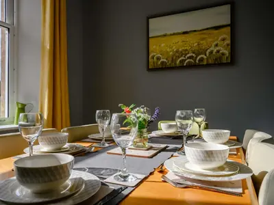 a table with plates and wine glasses and a herd of sheep at 3 Bed in Keswick 86867 in Keswick