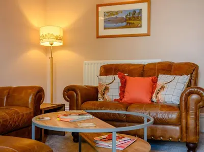 a living room with a leather couch and a table at 3 Bed in Keswick 86867 in Keswick