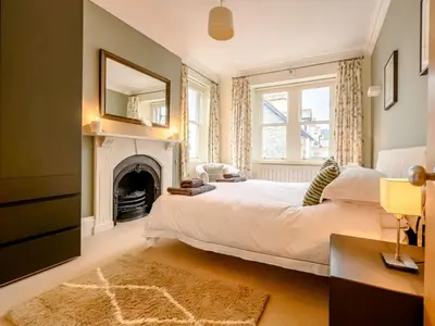 a bedroom with a large white bed and a fireplace at 4 Bed in Keswick oc-89258 in Keswick