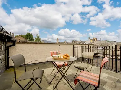a patio with a table and chairs on a balcony at 4 Bed in Keswick oc-89258 in Keswick