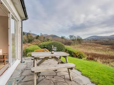 a picnic table on a patio with a view of the mountains at 2 Bed in Portinscale SZ071 in Portinscale