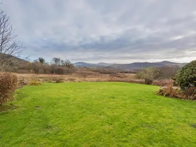 a large green field with mountains in the background at 2 Bed in Portinscale SZ071 in Portinscale