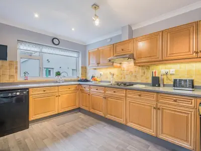 a large kitchen with wooden cabinets and a window at 2 Bed in Portinscale SZ071 in Portinscale