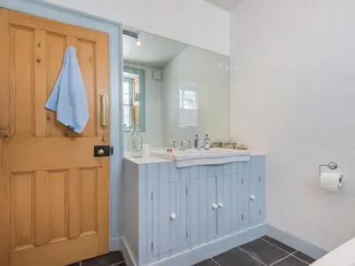 a bathroom with a sink and a mirror and a door at 2 Bed in Keswick oc-sz126 in Keswick