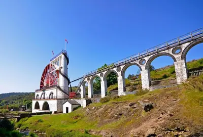 a bridge on top of a hill next to a mountain at The Cottage, Bridge House in Laxey