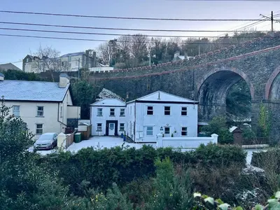 an old stone bridge with houses and a car in front at The Cottage, Bridge House in Laxey
