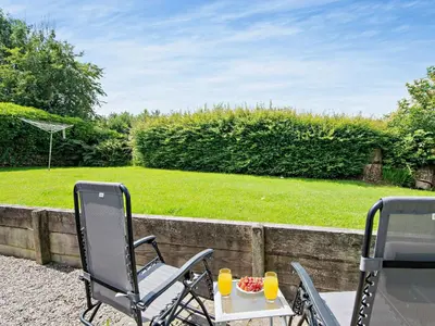 two chairs and a table with a bowl of fruit at 1 Bed in Balmaclellan CA371 in Castle Douglas
