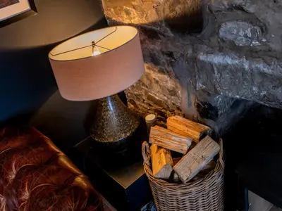 a lamp sitting on a table next to a basket at 3 Bed in Portpatrick 77308 in Portpatrick