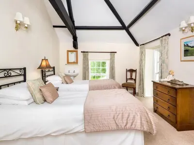 a bedroom with two beds and a dresser and a window at 6 Bed in Workington oc-sz151 in Lamplugh