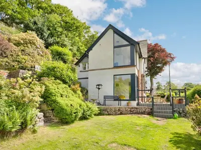 a small white house with a garden at 3 Bed in Eskdale SZ072 in Santon Bridge