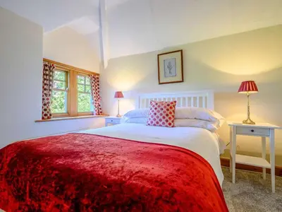 a bedroom with a large bed with a red blanket at 3 Bed in Eskdale SZ072 in Santon Bridge