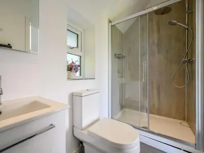 a bathroom with a shower and a toilet and a sink at 3 Bed in Eskdale SZ072 in Santon Bridge