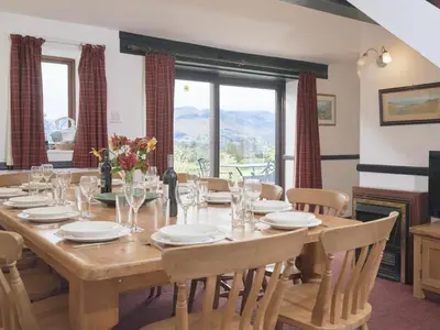 a dining room with a large wooden table with chairs at 8 Bed in Applethwaite SZ373 in Applethwaite