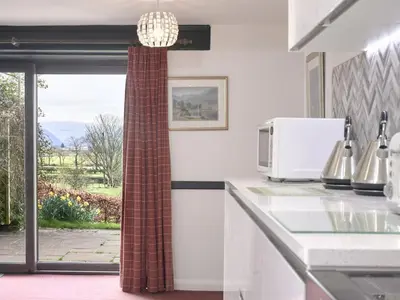 a kitchen with a counter with a microwave and a window at 8 Bed in Applethwaite SZ373 in Applethwaite