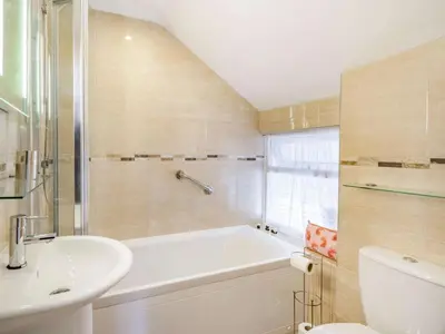 a bathroom with a tub and a sink and a toilet at 3 Bed in Keswick oc-sz446 in Portinscale