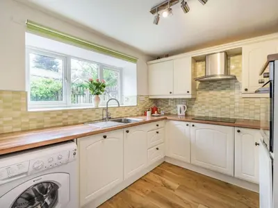 a kitchen with white cabinets and a washer and dryer at 3 Bed in Keswick oc-sz446 in Portinscale