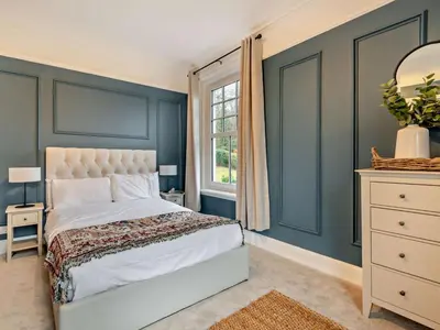 a bedroom with blue walls and a bed and a window at 9 Bed in Keswick oc-sz238 in Keswick