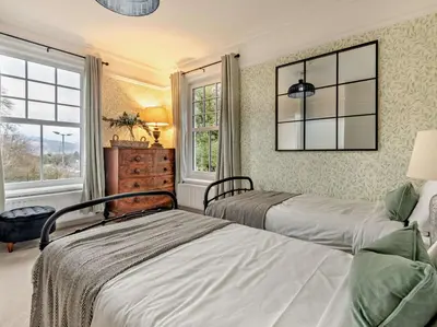 two beds in a bedroom with two windows at 9 Bed in Keswick oc-sz238 in Keswick
