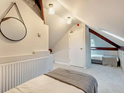 a attic bedroom with a bed and a mirror at 9 Bed in Keswick oc-sz238 in Keswick