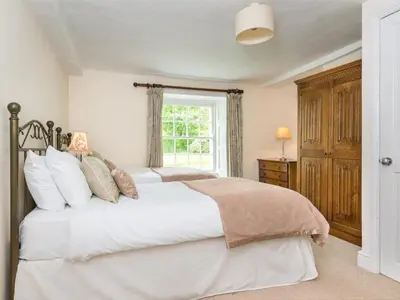 a bedroom with a large white bed with a window at 6 Bed in Workington oc-sz327 in Lamplugh