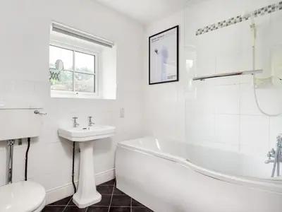 a white bathroom with a tub sink and a toilet at 6 Bed in Workington oc-sz327 in Lamplugh