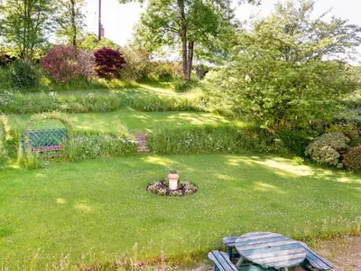 a garden with a table and a fountain in the grass at 6 Bed in Workington oc-sz327 in Lamplugh