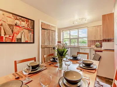 a dining room with a table with plates and wine glasses at 3 Bed in Keswick oc-sz148 in Grange