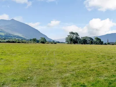 a field of green grass with mountains in the background at 3 Bed in Bassenthwaite 84024 in Bassenthwaite