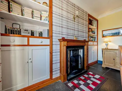 a living room with a fireplace and a book shelf at 3 Bed in Holmrook oc-sz414 in Santon Bridge