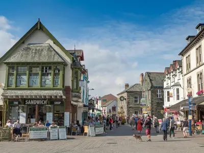 a group of people walking down a street in a town at 2 Bed in Keswick oc-sz140 in Keswick