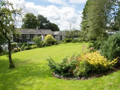 a house with a yard with green grass and flowers at 3 Bed in Threlkeld SZ421 in Threlkeld