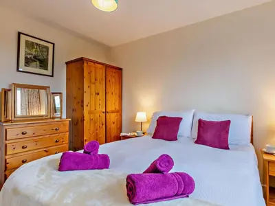 a bedroom with a large bed with purple towels on it at 2 Bed in Keswick oc-sz008 in Keswick