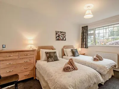 a bedroom with two beds and a dresser and a window at 2 Bed in Keswick oc-sz116 in Keswick