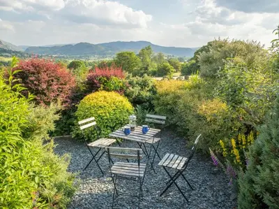 a table and chairs in the middle of a garden at 2 Bed in Threlkeld SZ082 in Threlkeld