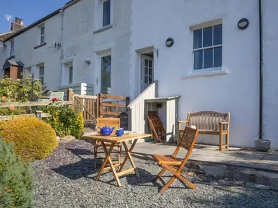 a table and chairs in front of a house at 2 Bed in Threlkeld SZ082 in Threlkeld
