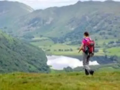 a person with a backpack standing on top of a hill at 2 Bed in Keswick oc-sz341 in Portinscale