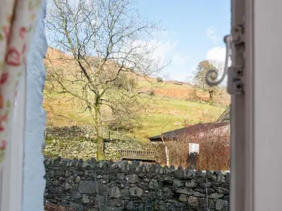 a window view of a stone wall with a tree at 2 Bed in Keswick oc-sz068 in Rosthwaite