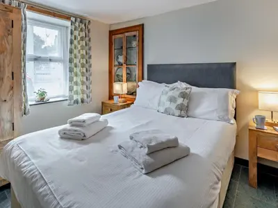 a bedroom with a large white bed with towels on it at 2 Bed in Ravenglass SZ409 in Ravenglass
