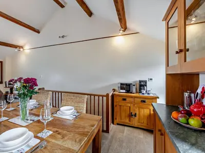 a kitchen with a wooden table and a dining room at 2 Bed in Ravenglass SZ409 in Ravenglass