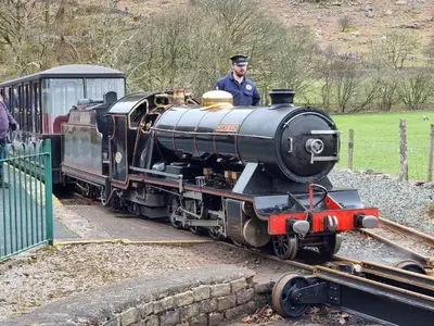 a man driving a small train on the tracks at 2 Bed in Ravenglass SZ409 in Ravenglass