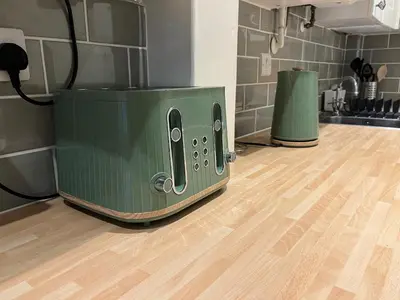 a green toaster sitting on top of a kitchen floor at Daffodil Cottage in Cockermouth