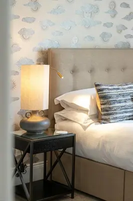 a bedroom with a bed with a table with a lamp at The Halston Carlisle in Carlisle